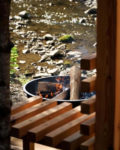 a boat in the water next to a river at Novosiele Residence - nad górską rzeką - Leśne Spa sauna jacuzzi - Bieszczady in Bystre