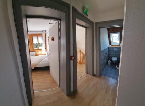 a hallway with a room with a bed and a bathroom at Chambres d'hôtes A la Fecht Nature et Bien-être in Sondernach