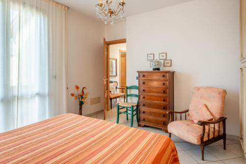 ein Schlafzimmer mit einem Bett, einem Stuhl und einer Kommode in der Unterkunft Villetta Grazia in Cascina