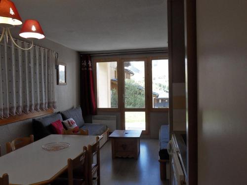 un salon avec une table et un canapé dans l'établissement Appartement cosy au pied des pistes avec terrasse - FR-1-181-2722, à La Plagne Tarentaise