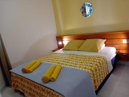 1 dormitorio con 2 camas con sábanas amarillas y almohadas amarillas en Appartement T2 climatisé La pépite, en Saint-François