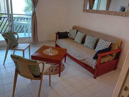 una sala de estar con un sofá y una mesa en Appartement T2 climatisé La pépite, en Saint-François
