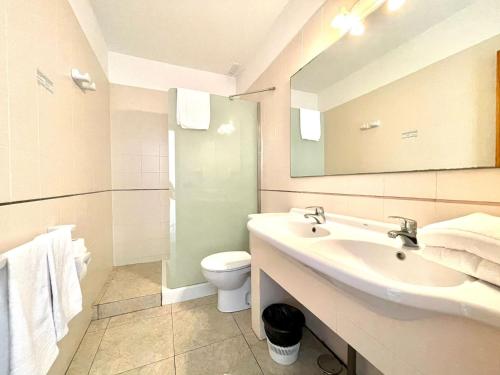 bagno con lavandino, servizi igienici e specchio di Oceanfront apartment a few meters from the beach a Tamaduste
