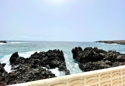 una vista del océano con rocas en el agua en Oceanfront apartment a few meters from the beach en Tamaduste