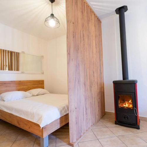 a bedroom with a bed and a wood stove at Apartman Lux Blidinje Risovac in Blidinje
