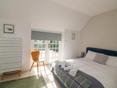 a bedroom with a bed with a chair and a window at Landmark in Salcombe