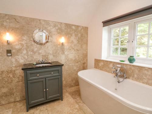 a bathroom with a bath tub and a sink at Landmark in Salcombe
