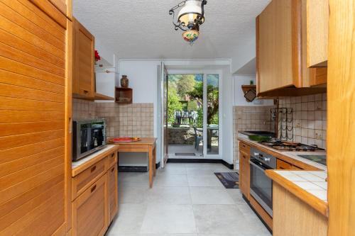 a kitchen with wooden cabinets and a view of a patio at La rivière de St Meme in Saint-Même