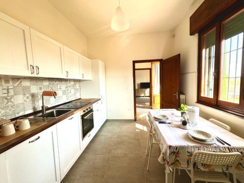 a kitchen with a table and a sink and a table and chairs at Casa Clelia in Ponte Buggianese