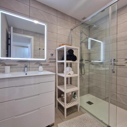 a bathroom with a sink and a shower with a mirror at Cozy Ocean view 1 BDR APT, Club Paraiso in Playa Paraiso