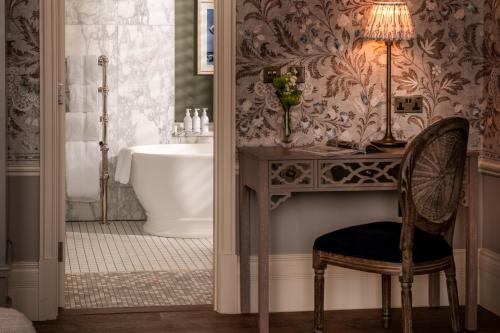 a bathroom with a chair and a sink and a tub at Langdale Chase Hotel in Windermere