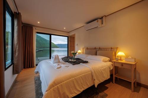 a bedroom with two beds and a large window at Lakeation kanchanaburi in Ban Wang Khun Knachen