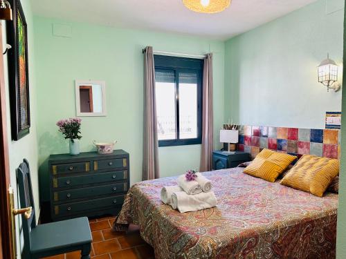 1 dormitorio con 1 cama con 2 toallas en Apartamentos Turísticos Santa Marina, en Aracena