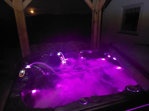 a purple bathtub with lights in a dark room at Crossways Cottage - Symonds Yat in Symonds Yat