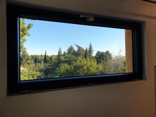 a window with a view of a forest at bungalow au calme in Saint-Savournin