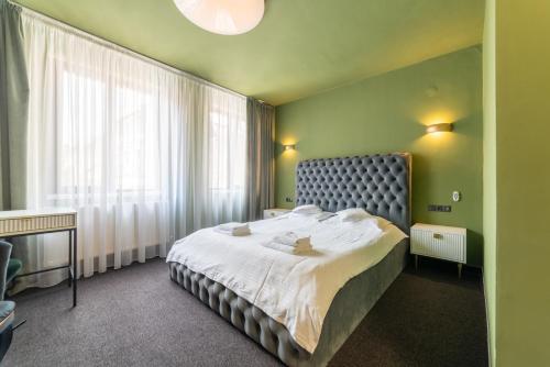 - une chambre avec un lit et une grande fenêtre dans l'établissement Fullton Central, à Cluj-Napoca