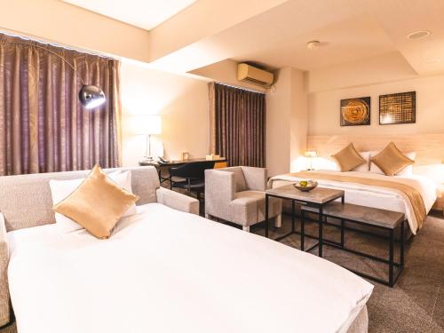 a hotel room with two beds and a table and chairs at Roppongi Hotel S in Tokyo