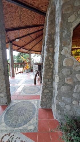 a stone building with a bench on a patio at Eco Farm Romantic Stone House with STARLINK internet 700 meters above sea level in Mambajao
