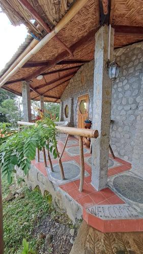 a patio with a table and a stone building at Eco Farm Romantic Stone House with STARLINK internet 700 meters above sea level in Mambajao