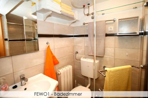 a bathroom with a sink and a toilet and a mirror at Anica Iles in Viskovo