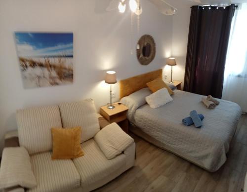 - une chambre avec 2 lits, un canapé et un miroir dans l'établissement Paraíso San Telmo, à Puerto de la Cruz