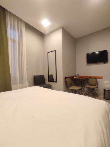 1 dormitorio con 1 cama y 1 mesa con sillas en Ore Pera Suites en Estambul