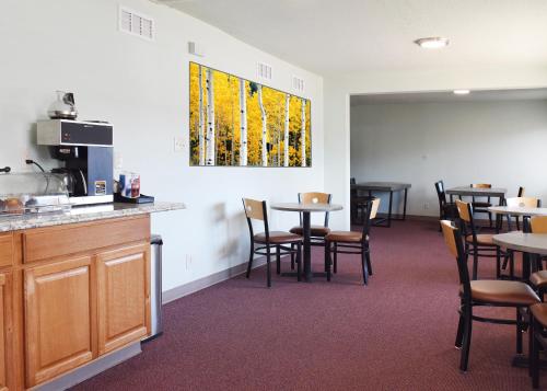 a waiting room with tables and chairs and a window at GREELEY UNIVERSITY INN/ GREELEY INN in Greeley