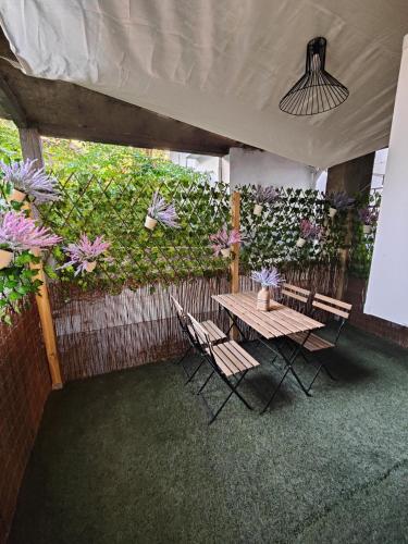 a patio with a table and chairs and flowers at Apartamentos Santander 1 in Santander