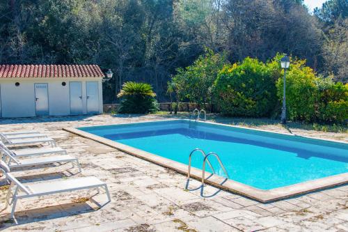 a swimming pool with chairs and a house at NEW Can Blanch 16th Century Masía Pool Chapel in Argentona