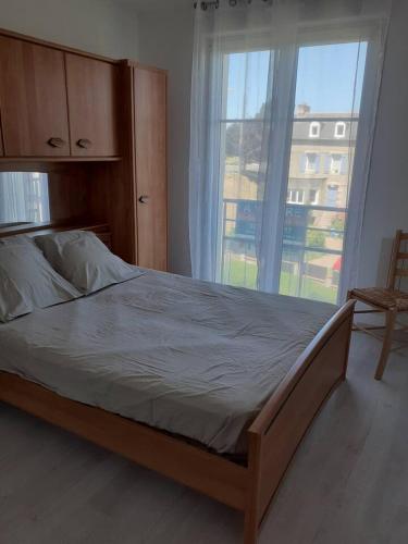 un lit dans une chambre avec une grande fenêtre dans l'établissement les jardins du casino, à Saint-Quay-Portrieux