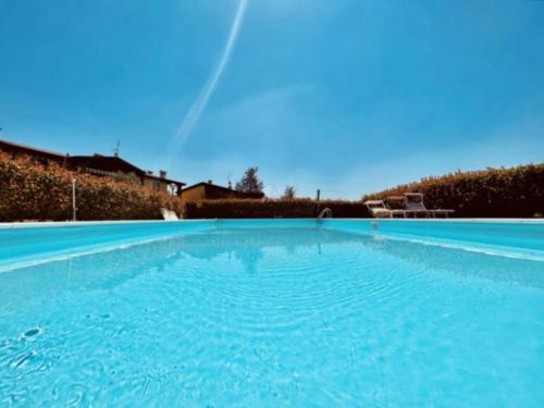 ein großer blauer Pool mit Regenbogen im Himmel in der Unterkunft Desenzanoloft Oasis in Desenzano del Garda