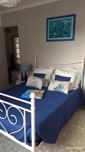 um quarto com uma cama com lençóis e almofadas azuis em LA MAISON DU BONHEUR em Velleron