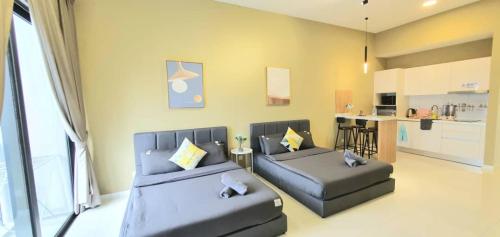 Chambers Residence Luxury Suites by Cozy Stay في كوالالمبور: غرفة معيشة مع كنبتين ومطبخ
