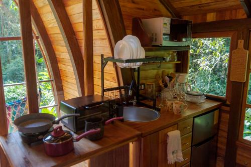 eine Küche mit einer Spüle und einem Herd in einer Hütte in der Unterkunft Sacha Urco Lodge y Bosque Protector in Mindo