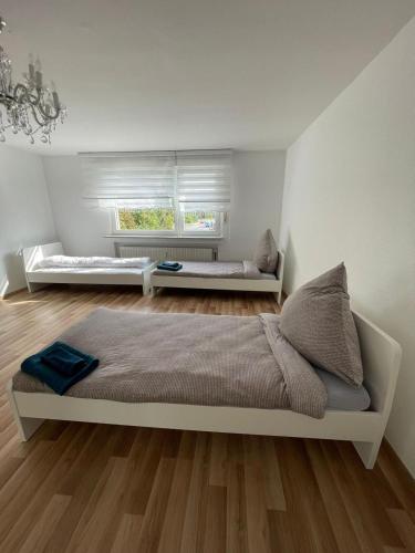 een witte slaapkamer met een bed en een raam bij Rio de Janeiro by estrella24 LIVING ROOMS in Castrop-Rauxel