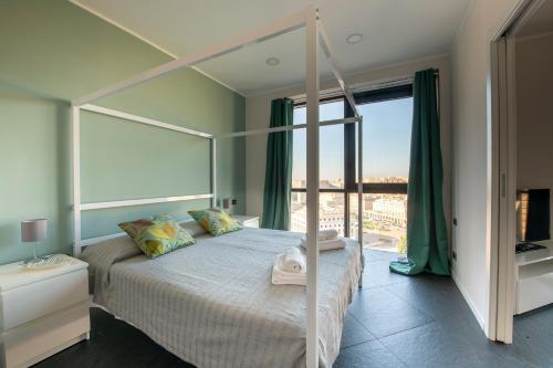 um quarto com uma cama de dossel e uma grande janela em 225 - La Corte Luxury Apartment, Centro città con vista panoramica e PARCHEGGIO PRIVATO GRATUITO INCLUSO em Génova
