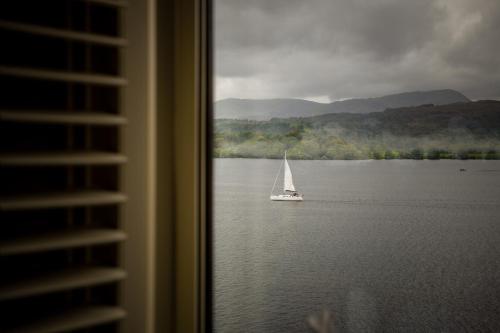 a sailboat on the water with a view from a window at Langdale Chase Hotel in Windermere