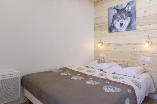 a bedroom with a wolf picture on the wall at Résidence Le Médian - Les Ménuires in Les Menuires