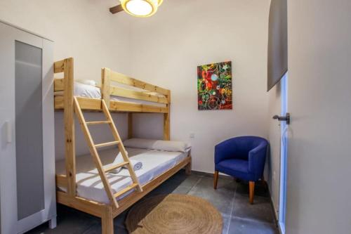 a bedroom with two bunk beds and a blue chair at Fantástica y amplia casa de diseño in Los Mártires