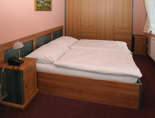 a bedroom with a bed with a wooden frame at Lázně Evženie in Klášterec nad Ohří