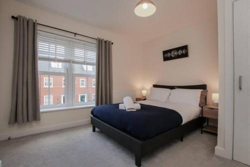a bedroom with a bed and a large window at Luxury Colchester House in Colchester