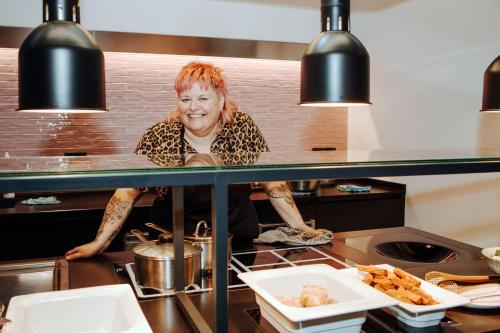 a woman standing behind a counter in a kitchen at Bio-Berghotel Ifenblick in Balderschwang