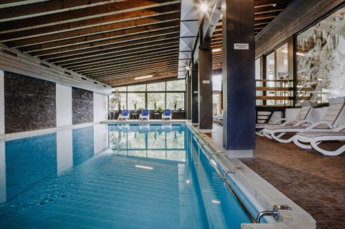 a swimming pool in a building with a large window at Bio-Berghotel Ifenblick in Balderschwang