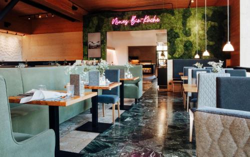 a restaurant with wooden tables and blue chairs at Bio-Berghotel Ifenblick in Balderschwang