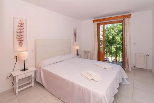 a bedroom with a white bed with two towels on it at Vora Mar Beachfront Apartment by Sealand Villas in Port de Pollensa
