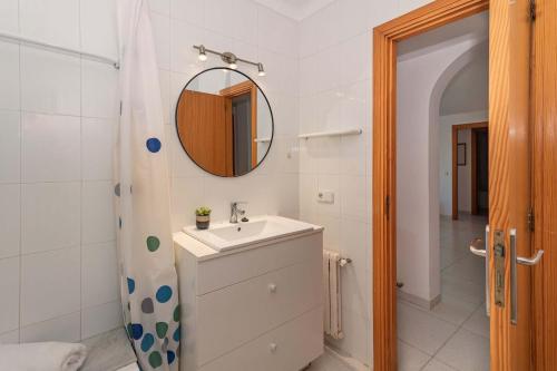 a bathroom with a sink and a mirror and a shower at Vora Mar Beachfront Apartment by Sealand Villas in Port de Pollensa
