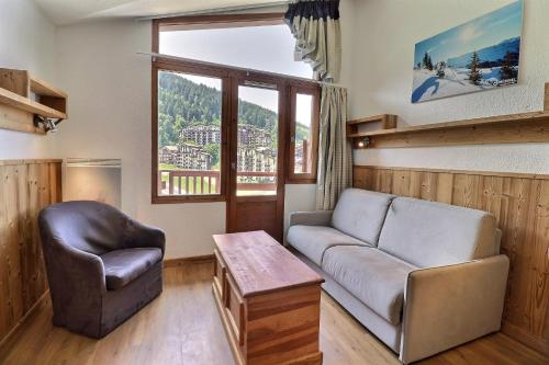 a living room with a couch and a chair at Le Grand Bois in Courchevel