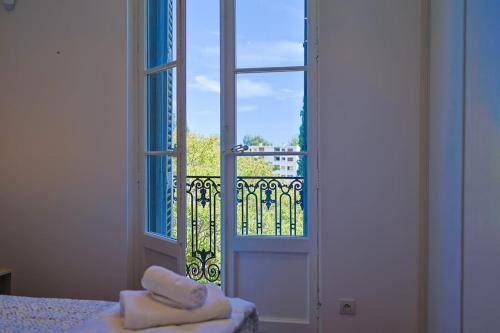 a door with two towels on a bed next to a window at Maison de Maître Centre Ville in Hyères