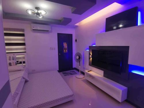 - un salon violet avec une télévision à écran plat dans l'établissement Home in Cabanatuan city, à Cabanatuan
