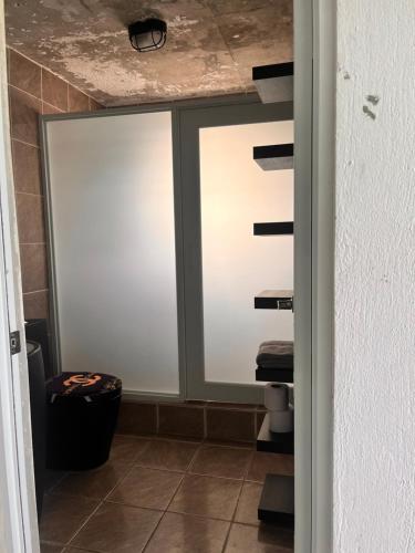 a bathroom with sliding glass doors and a toilet at Portobelo in San Juan